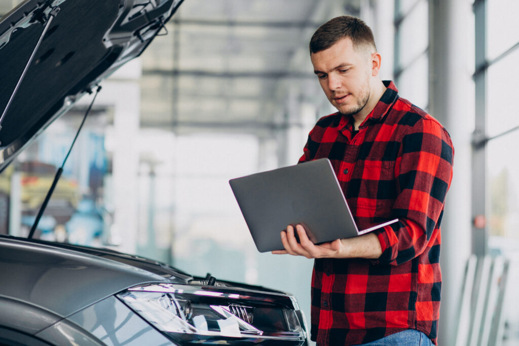 young man making diagnostics of the vehicle young man making diagnostics of the vehicle